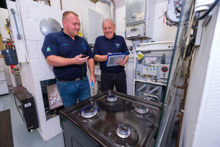 Gas student and trainer working on a gas hob